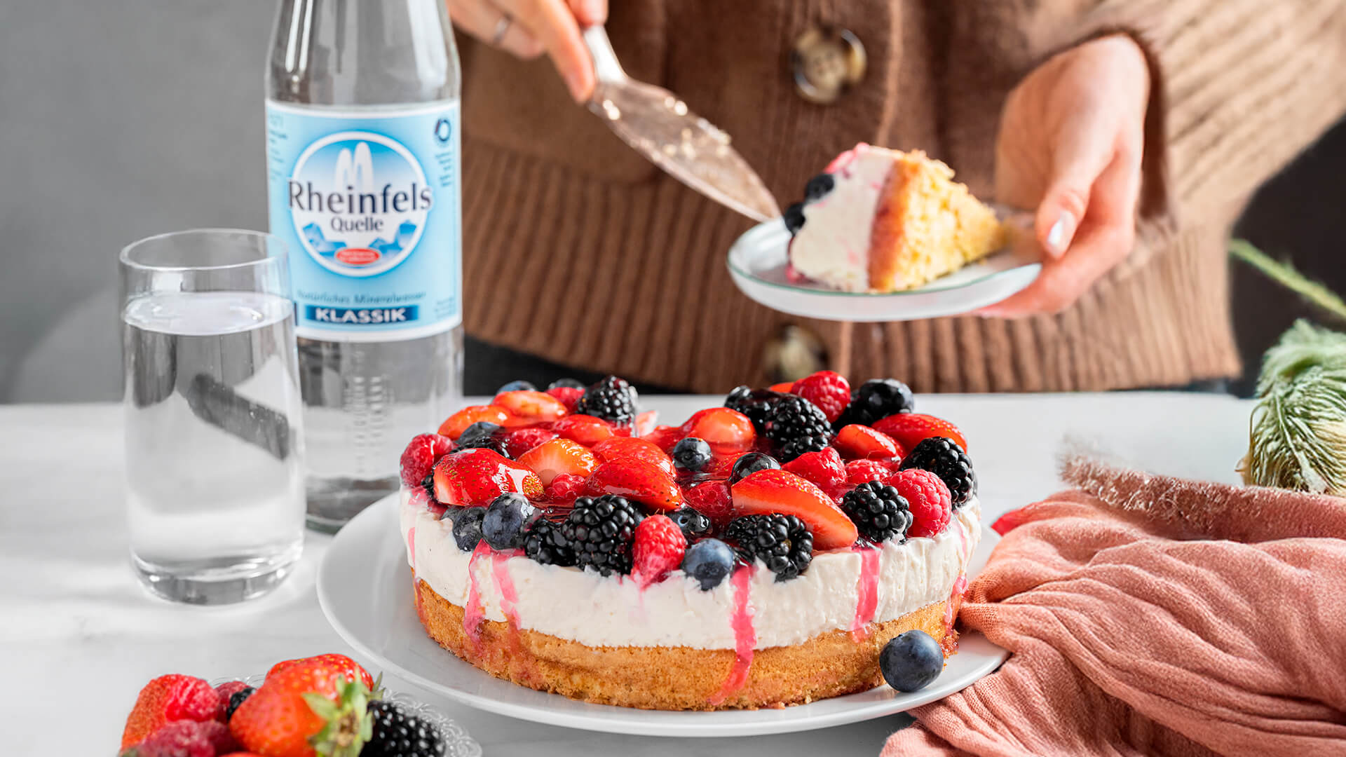 Beeren Torte mit einer Rheinfels Quelle Klassik Flasche