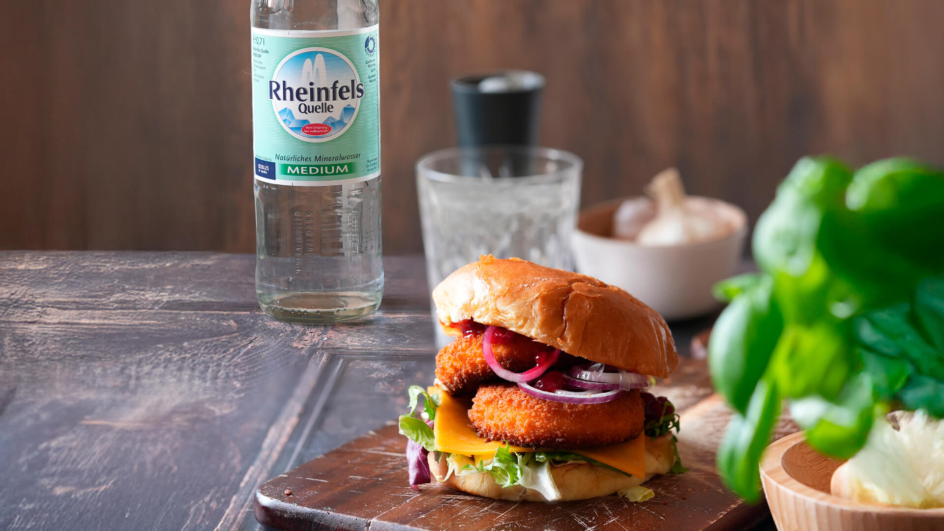 Camembert Burger mit einer Rheinfels Quelle Medium Flasche