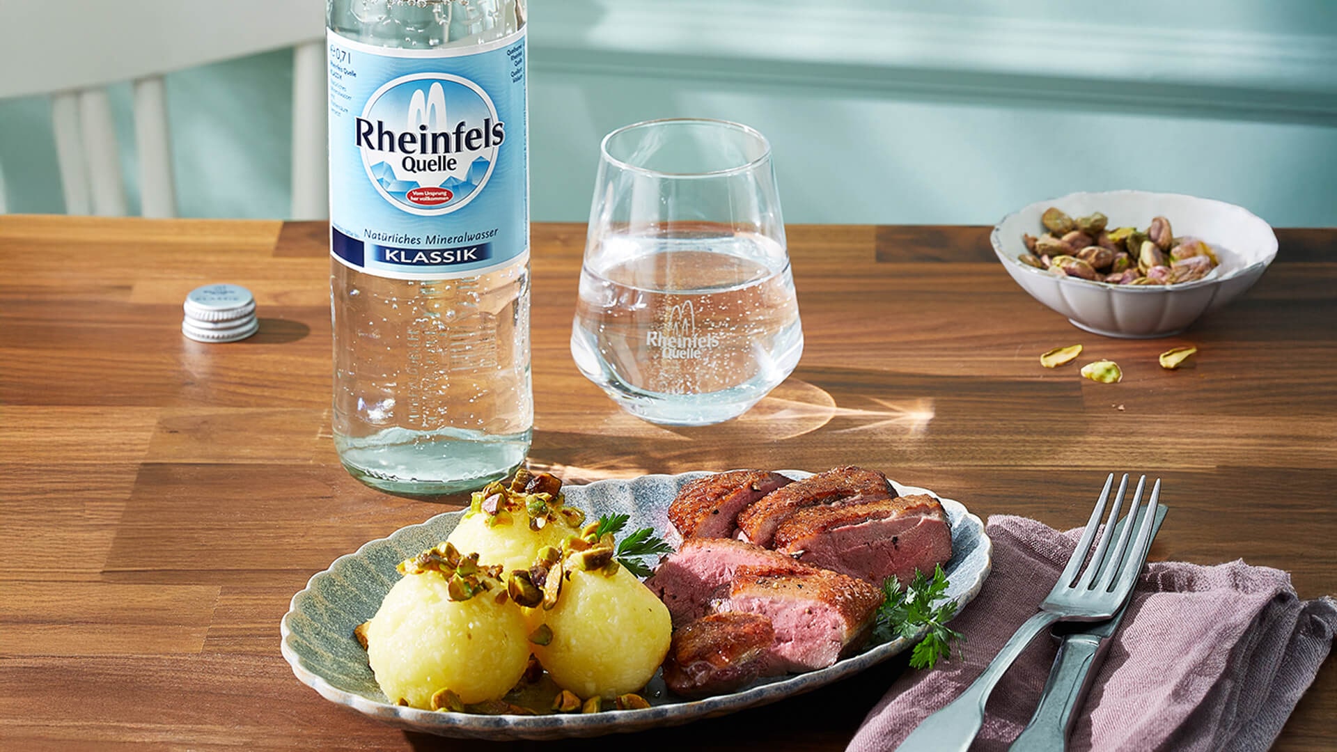 Entenbrust mit Knödeln und eine Flasche Rheinfels Quelle Klassik