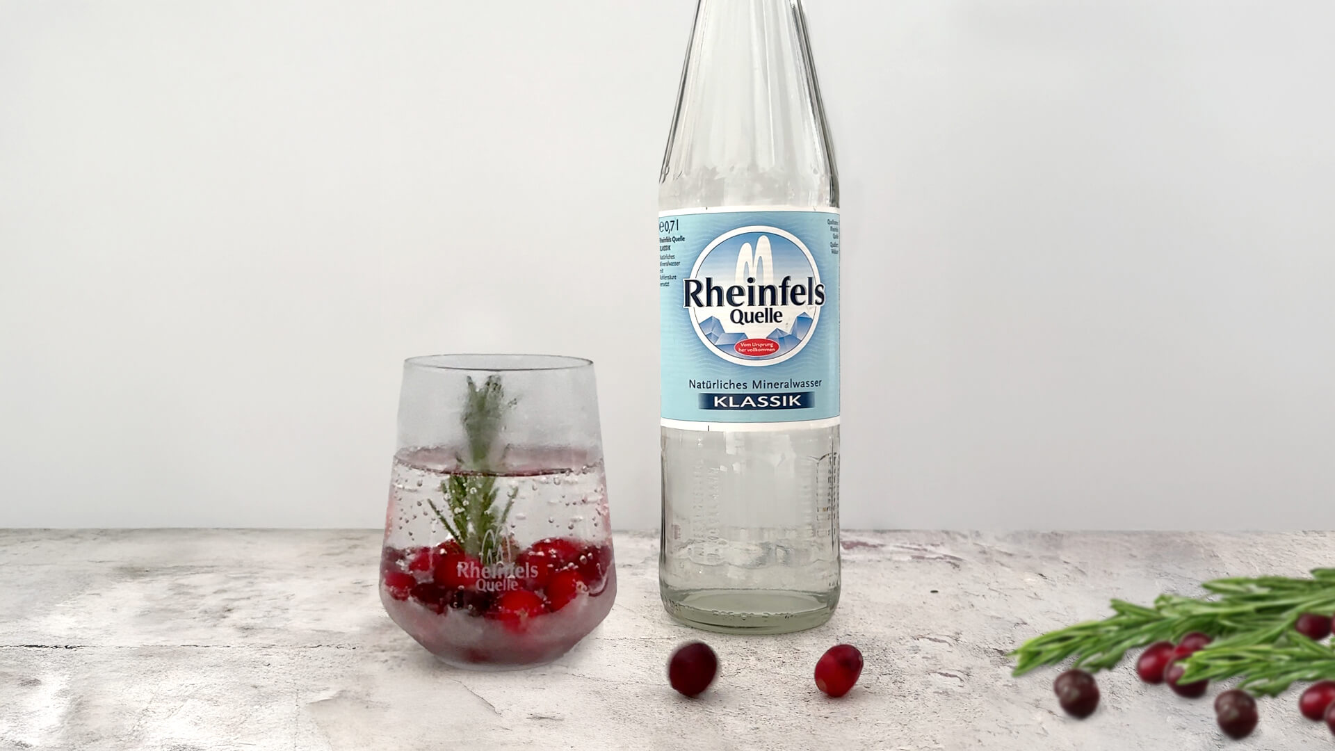 Cranberries in einem Glas neben Rheinfels Quelle Klassik