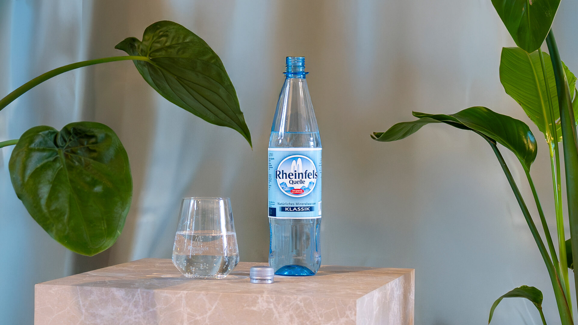 Flasche Rheinfels Klassik, daneben ein gefülltes Wasserglas